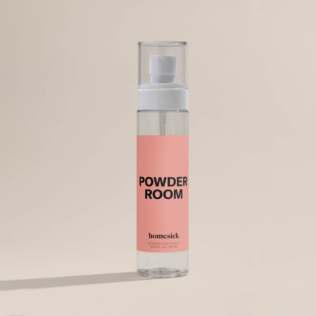A product shot of the Powder Room Linen spray shot on a dark cream background.