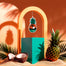 Lifestyle image of a car freshener surrounded by sand and pineapples