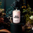 Lifestyle image of a candle surrounded by forest elements in a dark scene