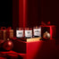 All three lit Winter Wonderland Mini Candles surrounded by presents and Christmas tree ornaments.