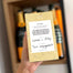 View of the back of the box with a personal message that reads "Cheers to Lauren and Riley" new line "Lets Celebrate your engagement"