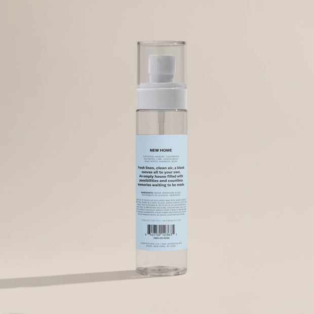 A product shot that shows the back labeling of the New Home Room Spray.