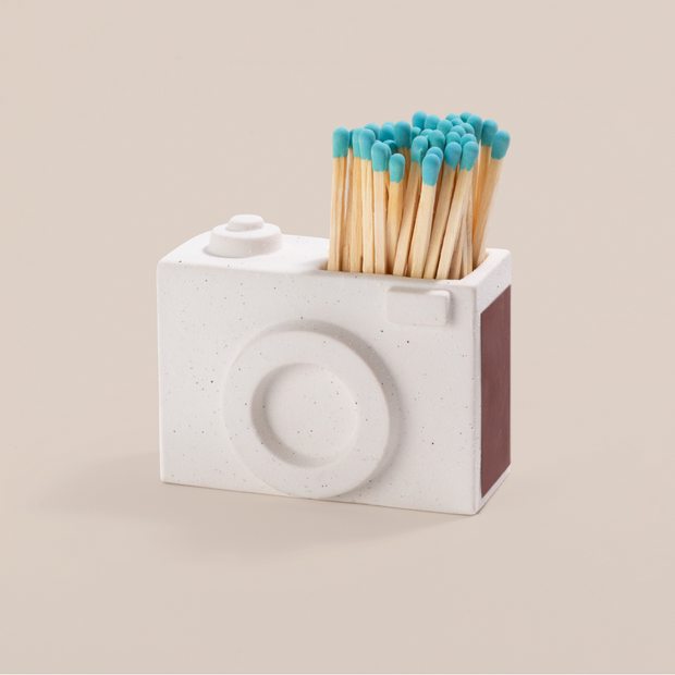 A match holder that is shaped like a mini camera.