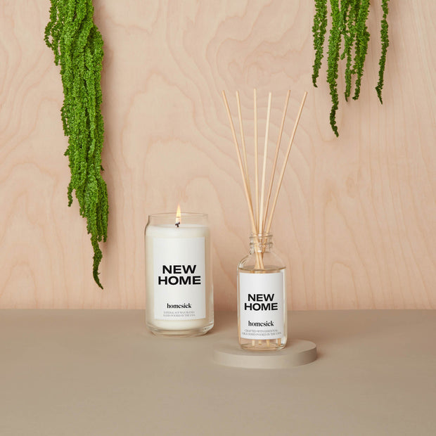 New Home candle next to the new home diffuser with a neutral background.