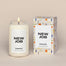 A lit New Job Homesick candle displayed next to its boxed packaging on a dark cream background.