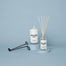 Lit New York City Candle placed next to a New York City diffuser along with a wick trimmer.