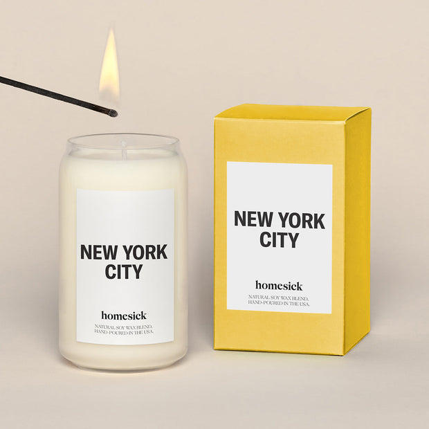 New York City candles placed next to the yellow packing box that it delivers in.