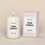 A generic Homesick candle that is lit. The candle label and its packaging display where a customized logo can be added.