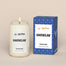 A lit Ravenclaw Homesick candle displayed next to its boxed packaging on a dark cream background.
