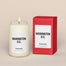 A lit Washington, D.C. Homesick candle displayed next to its boxed packaging on a dark cream background.