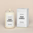 A generic Homesick candle that is lit. The candle label and its packaging display where a customized logo can be added.