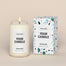 A generic Homesick candle that is lit. The candle label and its packaging display where a customized logo can be added.